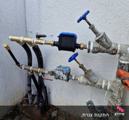 צינורות ומחברים עם ברזים כחולים ואדומים